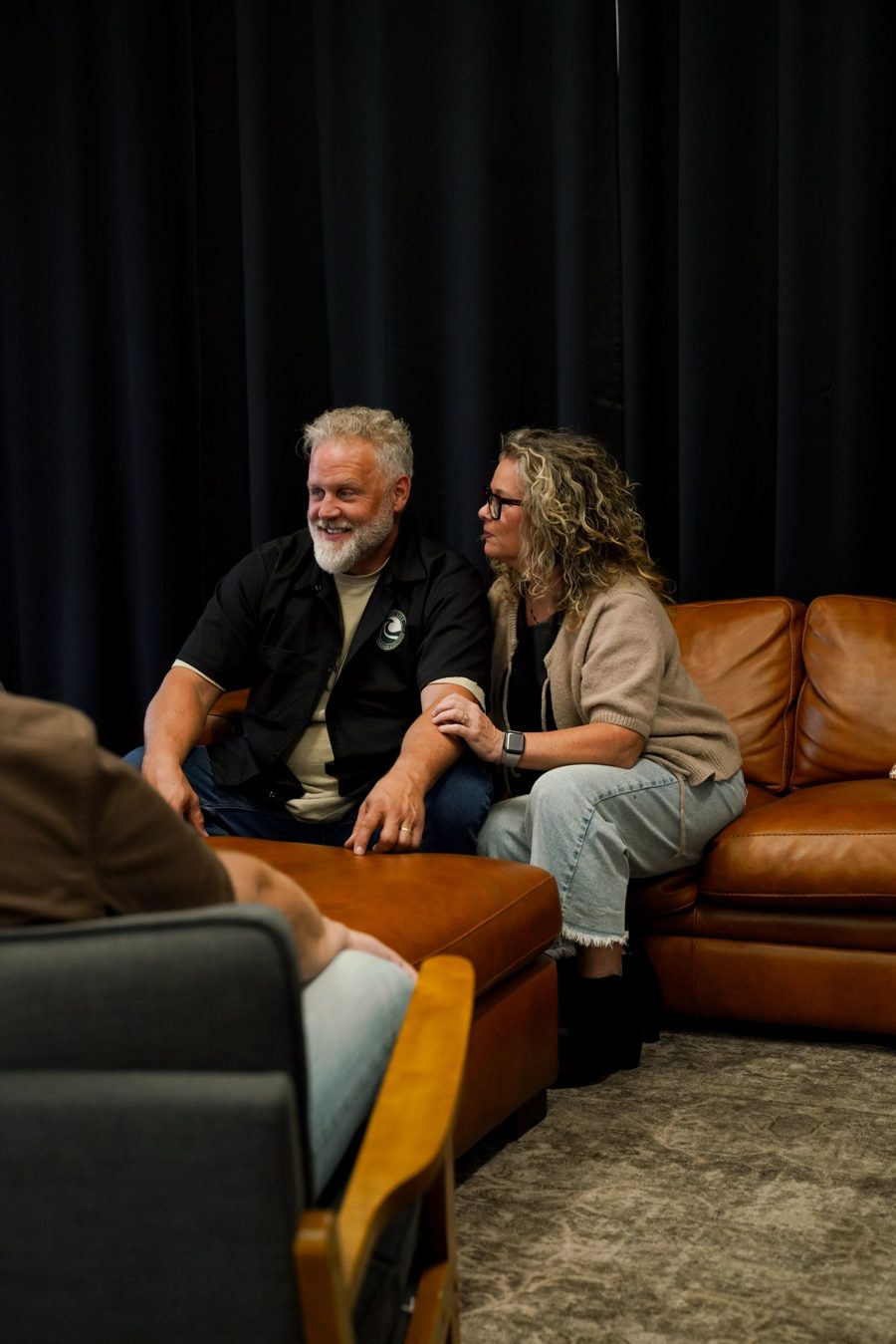 Doug and Gretchen talking with couples from a leather couch